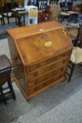 A reproduction yew wood veneered bureau with inlaid decoration
