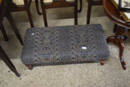 A blue upholstered footstool