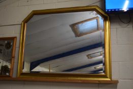 A contemporary bevelled over mantel mirror in gilt wood effect frame
