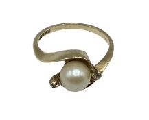 A 9ct gold pearl and diamond set ring. Central pearl with diamond accents. 2.56g. Size M.