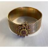 An 18ct tri-coloured gold belt bracelet with ruby set flower clasp 69.3g