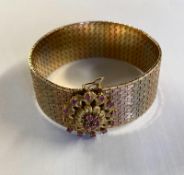 An 18ct tri-coloured gold belt bracelet with ruby set flower clasp 69.3g