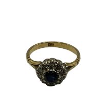 A 22ct gold sapphire and diamond ring, central round cut sapphire with a surround of single cut