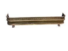 A pierced brass fire fender