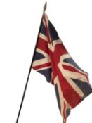 A late C19th/early C20th union jack on wooden staff, with pointed finial 224cm long, wear and losses