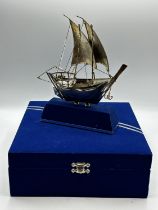A 925 silver model of a sailing ship in presentation box. 23cm x 18cm. On stand.