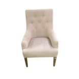 A modern cream upholstered button back chair, raised on wooden feet, some areas of wear/marks