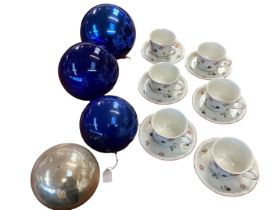 A Villeroy and Boch six person ceramic tea service, together with four large blown glass balls.