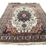 A large Tabriz rug, with central cream ground and borders, and all over stylized design with browns,