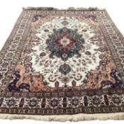 A large Tabriz rug, with central cream ground and borders, and all over stylized design with browns,