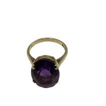 A 9ct gold and amethyst dress ring. Central oval free cut amethyst, Approx 17mm x 12mm in a four