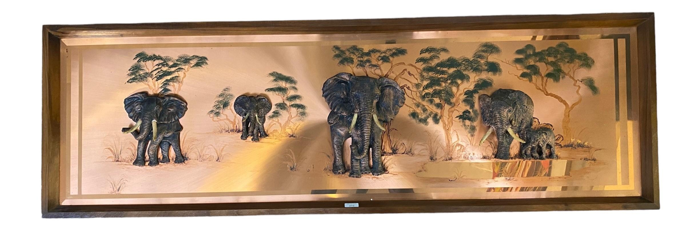 A wooden framed wall panel of elephants, signed Rangal, the sculptures of the elephants raised on