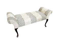 An upholstered window stool, with scrolling ends, and raised on mahogany legs, 124cm W x 46cm D x