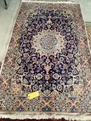 A Persian wool rug, blue and beige ground, with central star medallion, 114cm x 215cm, cleared
