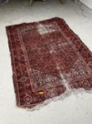A Persian style rug, with red ground, some wear and in used condition, sold as seen