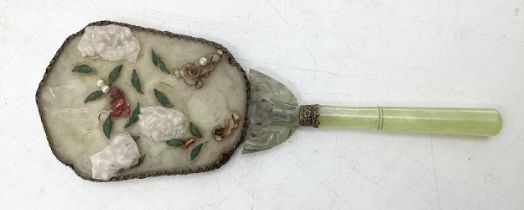 A dressing table hand mirror, decorated to back with carved jade style flowers and fauna