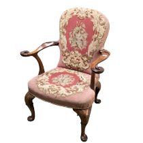 A walnut framed chair with tapestry upholstery, and scrolling arms with carved bird finials,