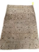 A modern cream ground rug, with all over stylized pattern, in used condition, sold as found