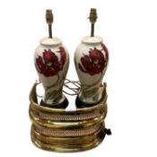 A pair of modern Moorcroft lamps, cream ground with red tulip flower design and a brass fender,