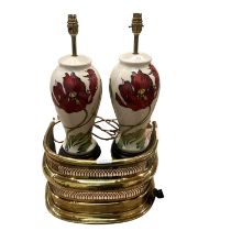 A pair of modern Moorcroft lamps, cream ground with red tulip flower design and a brass fender,