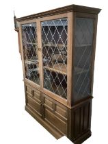 A modern glass doored cabinet, the glass doors with diamond lead lined design, and two cupboard