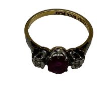 An 18ct gold and platinum ring. Central oval free cut ruby with illusion set diamond accents. Size