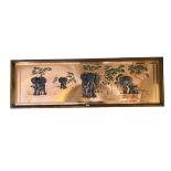 A wooden framed wall panel of elephants, signed Rangal, the sculptures of the elephants raised on