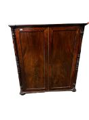 A William IV mahogany bookcase with three adjustable shelves, enclosed by rectangular panelled doors