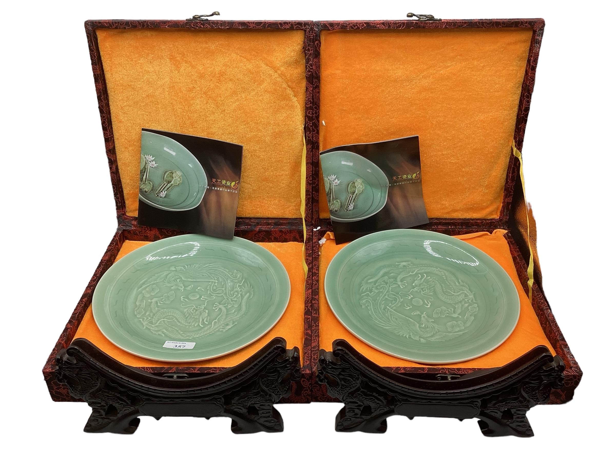 Two Chinese celadon chargers in presentation boxes stylised phoenix and dragon decoration with