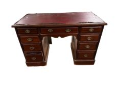 A mahogany pedestal desk, with red leather style top. Much fading and wear to top, 121cmW x 61cmD