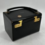 ASPREY, a black leather travelling vanity box, with handle, and combination clasps, with maroon silk