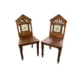 A pair of mahogany aesthetic movement hall chairs, with arched back and inlaid marquetry design to