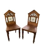 A pair of mahogany aesthetic movement hall chairs, with arched back and inlaid marquetry design to