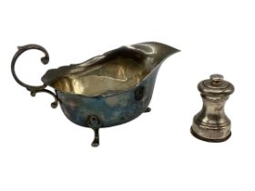 A sterling silver sauceboat together with a sterling silver mini pepper grinder. William Suckling,