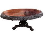 A C19th carved Indian blackwood round pedestal table with pierced foliate frieze, the base carved