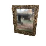 A contemporary decorative mirror, the frame modelled as intertwined drift wood twigs, 75 cm W x 98cm