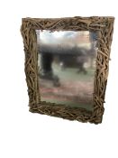 A contemporary decorative mirror, the frame modelled as intertwined drift wood twigs, 75 cm W x 98cm