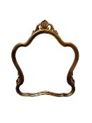 A modern gilt frame wall mirror, with curved shaped surround and foliate design to each side and