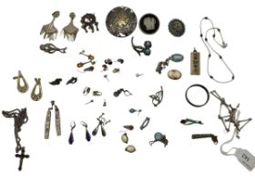 A collection of silver and white metal items to include a Peruvian wheel brooch, silver ingot