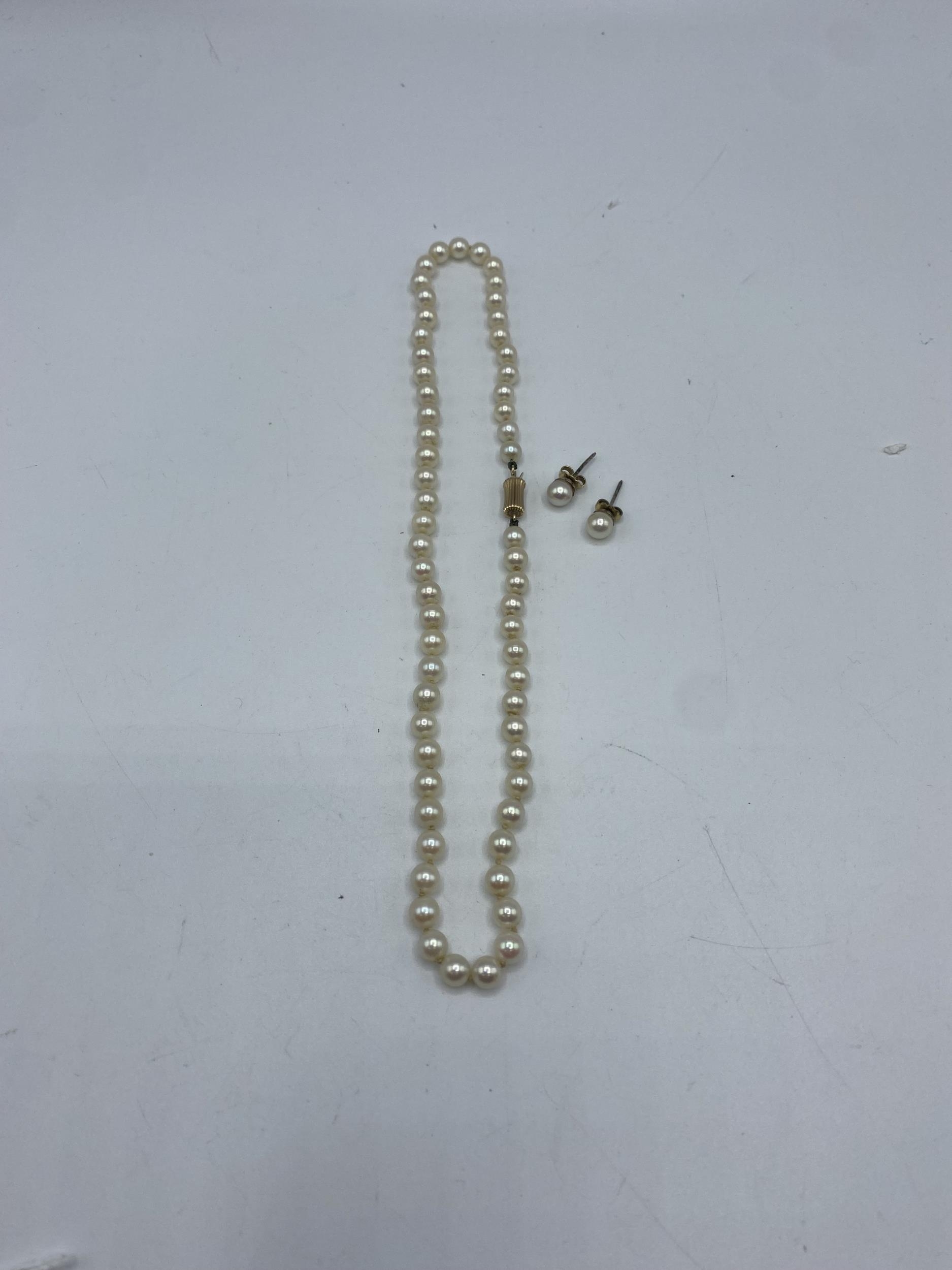 A strand of graduated cultured pearls on a 14ct gold clasp with matching ear studs. 40cm