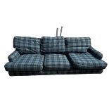 A three seater blue tartan upholstered sofa, and a blue upholstered foot stool (115cm x 77cm). 250