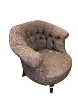 A brown upholstered low tub chair with button backed, and black wooden legs to castors