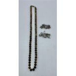 A jet style bead necklace with gilt decoration together with two marcasite brooches.