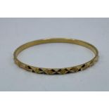 A middle eastern yellow metal bangle with Arabic marks to hoop. 16.7g.