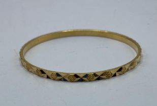 A middle eastern yellow metal bangle with Arabic marks to hoop. 16.7g.