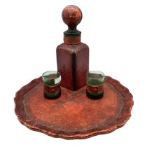 A C20th leather scalloped tray and decanter and two glasses
