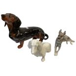 Three china dogs to include a Beswick Dachsund, A German Shepherd, Nymphenburg seated dog