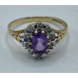 A 9ct gold amethyst and diamond ring. Central oval free cut amethyst with a surround of illusion set
