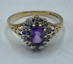 A 9ct gold amethyst and diamond ring. Central oval free cut amethyst with a surround of illusion set
