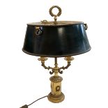 A traditional brass library table lamp with a 3 branch light to a green shade